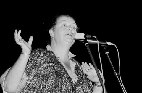 Photograph of Brenda Wootton singing at a microphone.