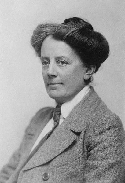 A photography of Ethel Smyth. She is wearing a tweed jacket and tie and has her hair up in a bun.